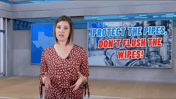 Person speaking in a studio stands before a screen displaying the message “Protect the Pipes, Don’t Flush the Wipes!” with industrial pipe imagery in the background.